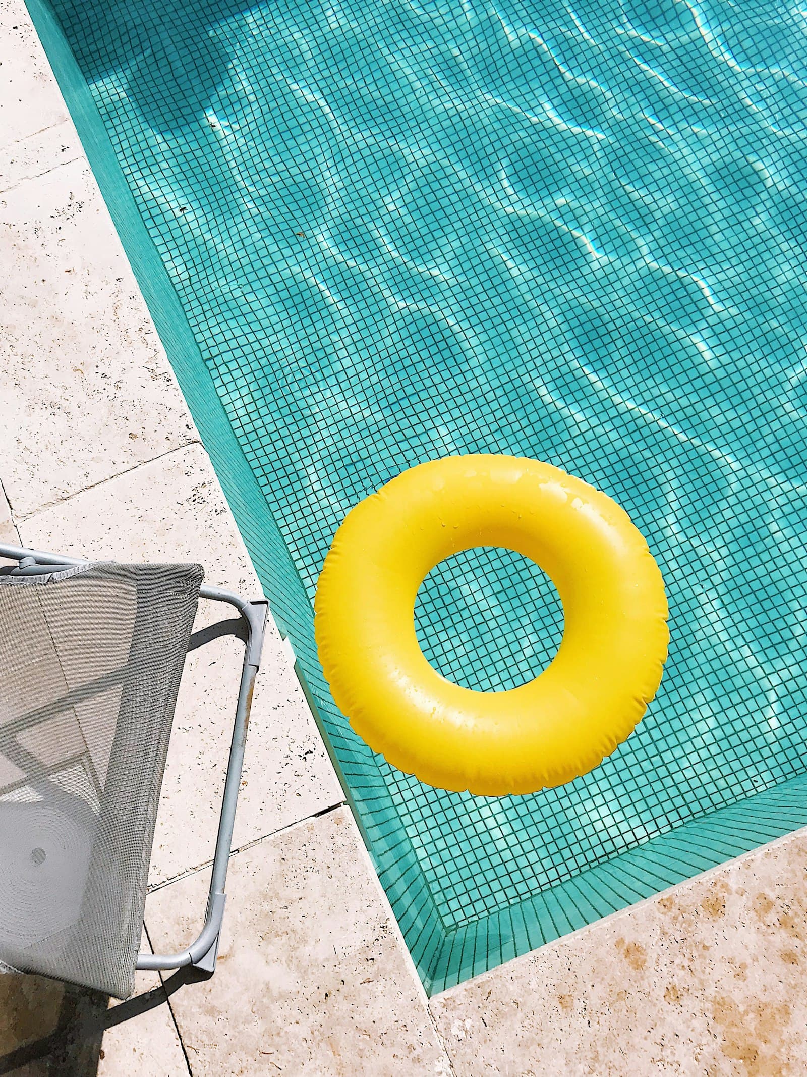 Boia amarela a flutuar na esquina de uma piscina azul