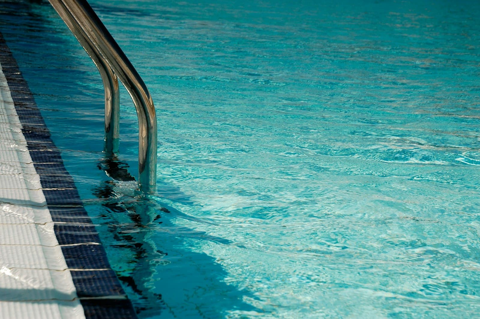 Escada de inox numa piscina de água transparente