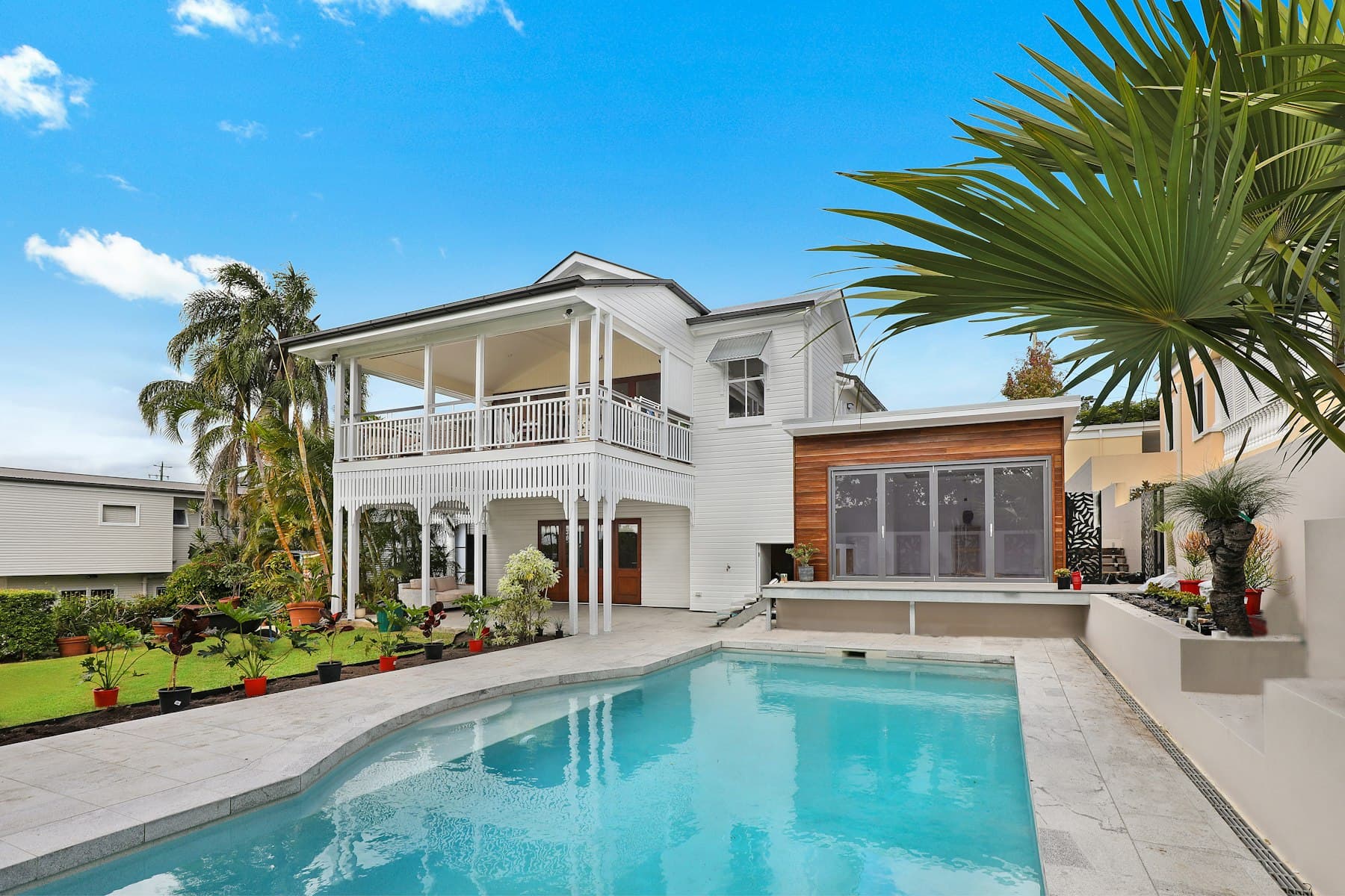 Casa com jardim e piscina de água transparente ao sol